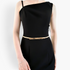 Beach Rose Co. slim gold-toned metal waist belt with a polished rectangular clasp worn over a black dress.