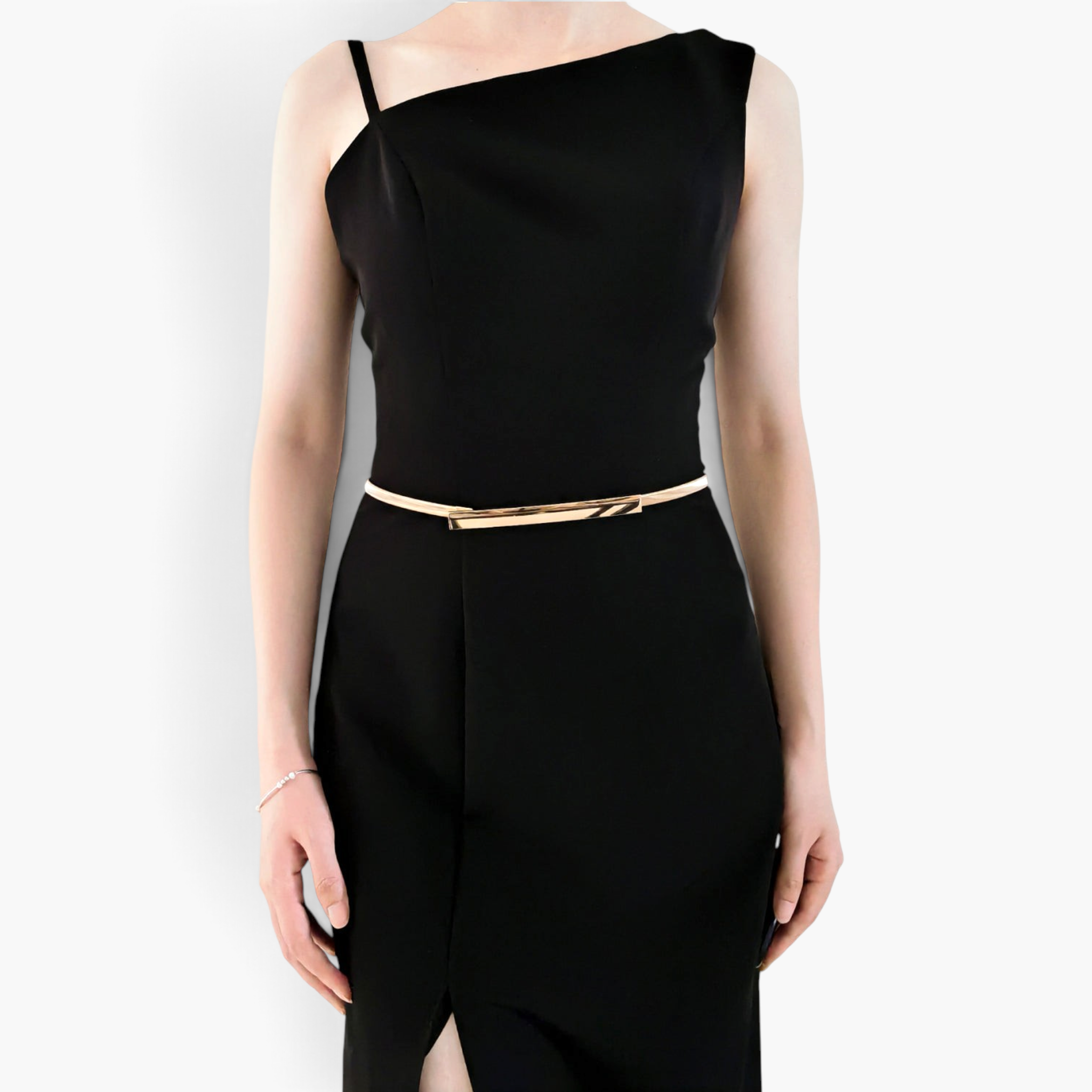Beach Rose Co. slim gold-toned iron waist belt with a rectangular clasp worn over a sleek black dress
