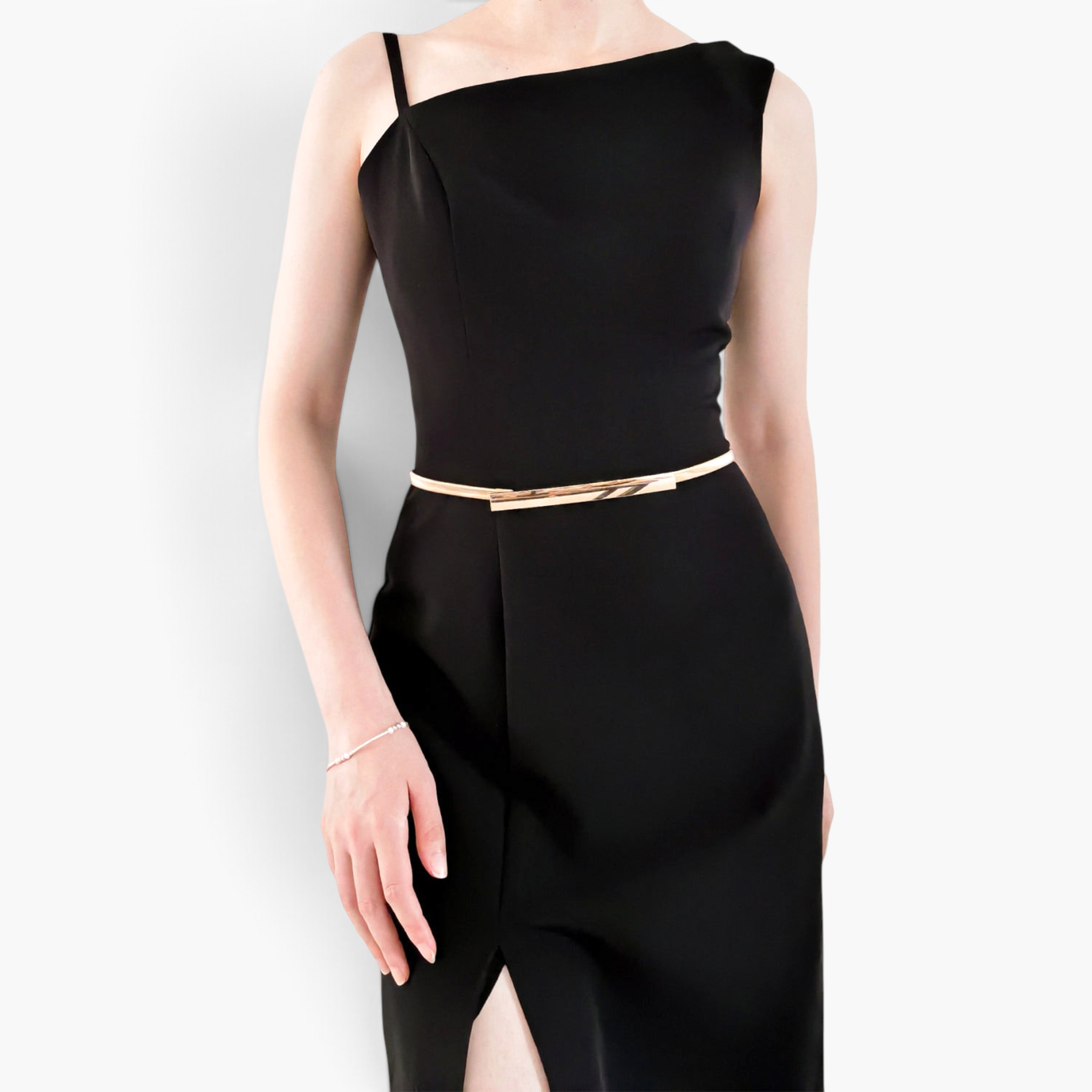 Beach Rose Co. slim gold-toned metal waist belt with a rectangular clasp worn over a black sleeveless dress