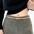 Beach Rose Co. slim gold-tone iron waist belt with a polished rectangular clasp worn over grey wool trousers