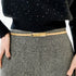 Beach Rose Co. slim gold-tone iron waist belt with a polished rectangular clasp worn over a grey tweed skirt