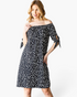 Beach Rose Co. black and ivory spotted off-shoulder dress with tie-sleeve details on a model