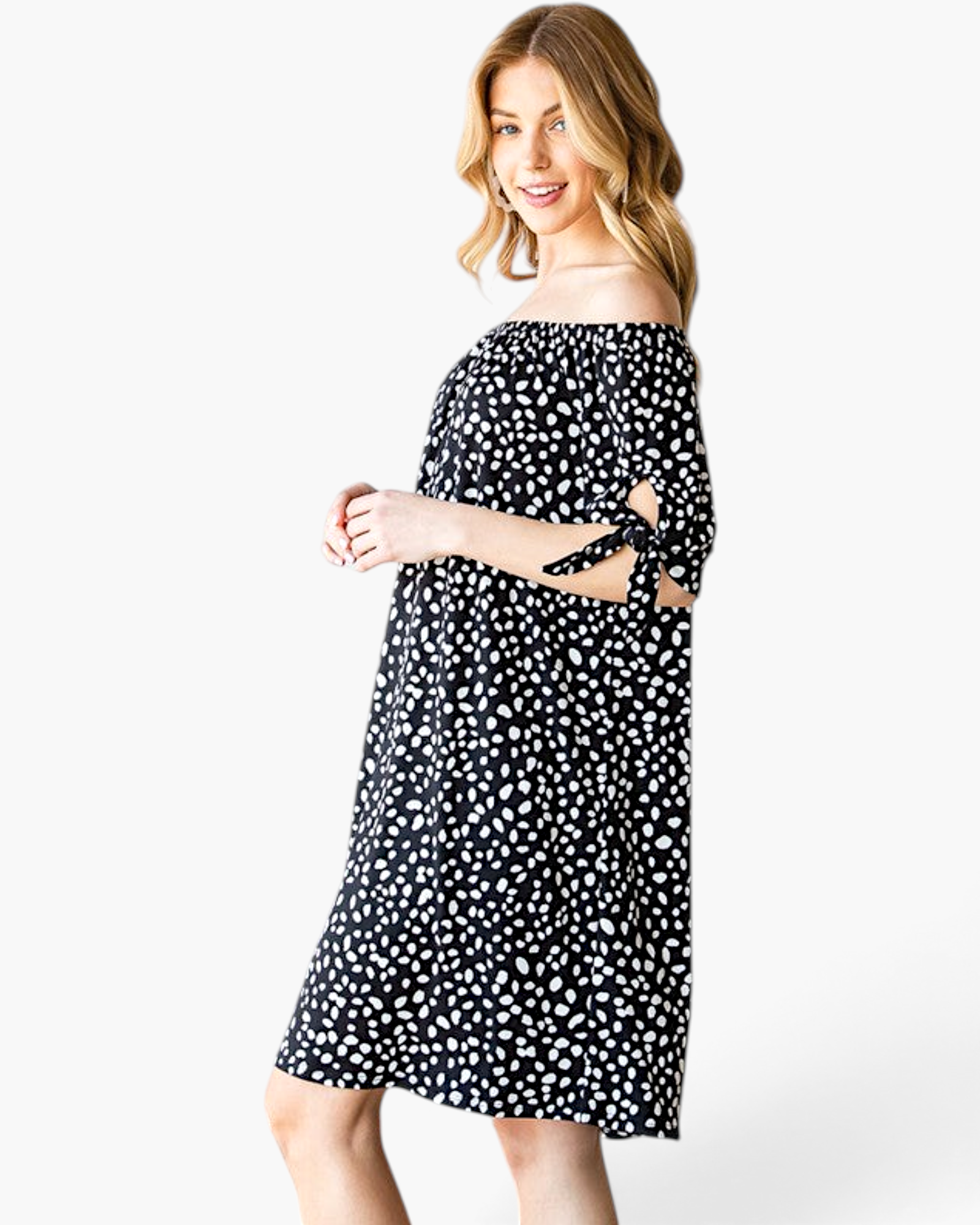 Beach Rose Co. black and ivory spotted off-shoulder dress with tie-sleeve details on a model