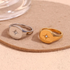 Beach Rose Co. gold and silver stainless steel signet rings with engraved starburst and clear zircon centerpieces