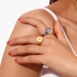 Beach Rose Co. gold and silver signet rings with engraved starbursts and zircon stones worn on a model's hand.