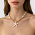 Beach Rose Co. 18K gold-plated necklace featuring elongated faux pearls, gold beads, and an iridescent starfish pendant.