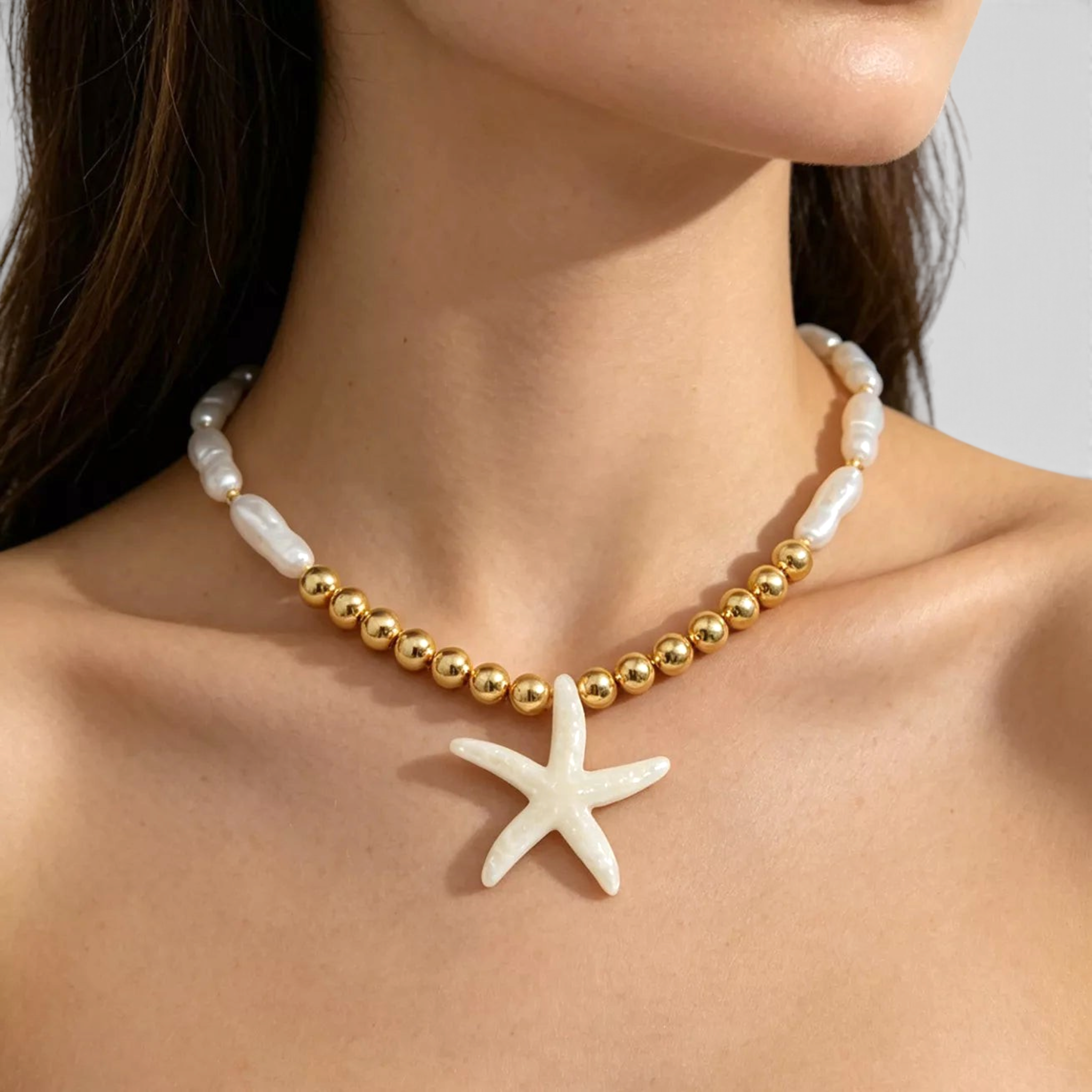 Beach Rose Co. 18K gold-plated necklace featuring faux pearl beads, gold spheres, and an iridescent starfish pendant.