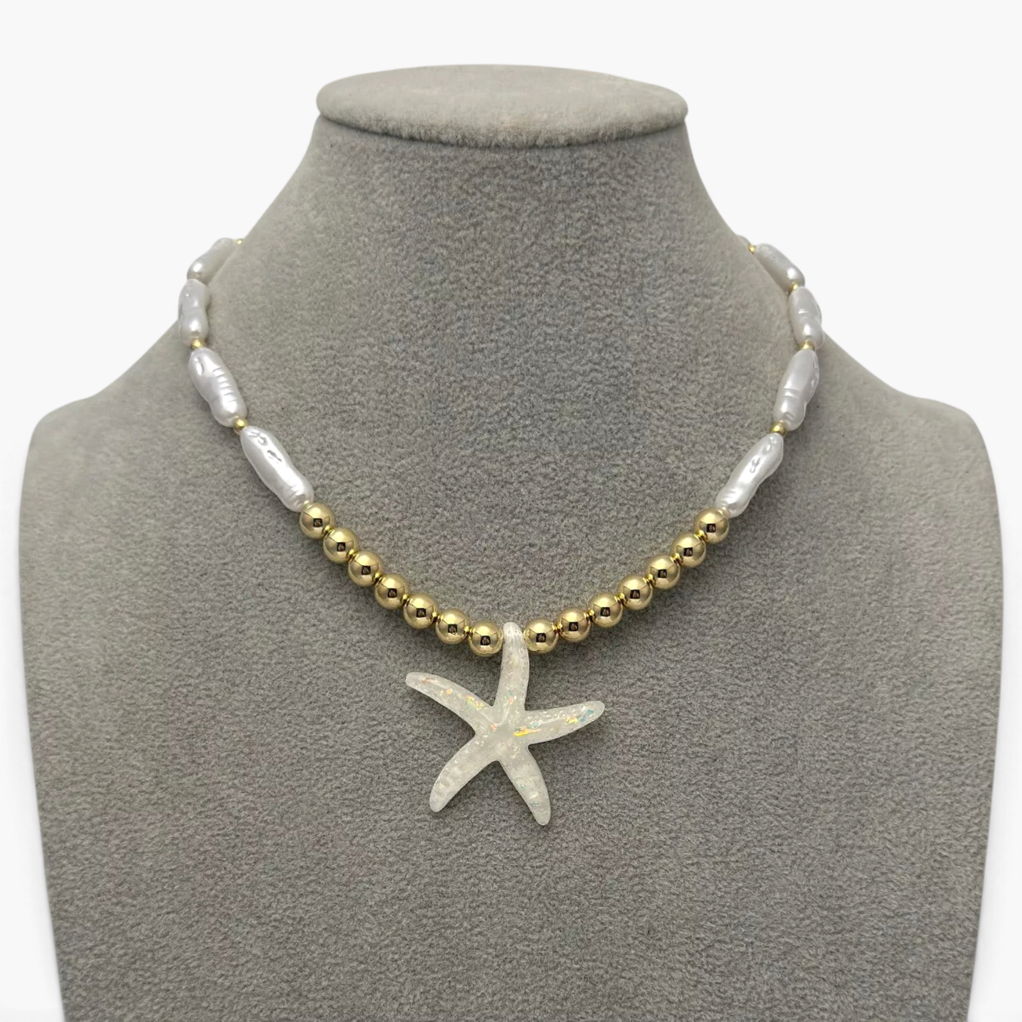 Beach Rose Co. 18K gold-plated necklace featuring elongated faux pearls, gold beads, and an iridescent starfish pendant.