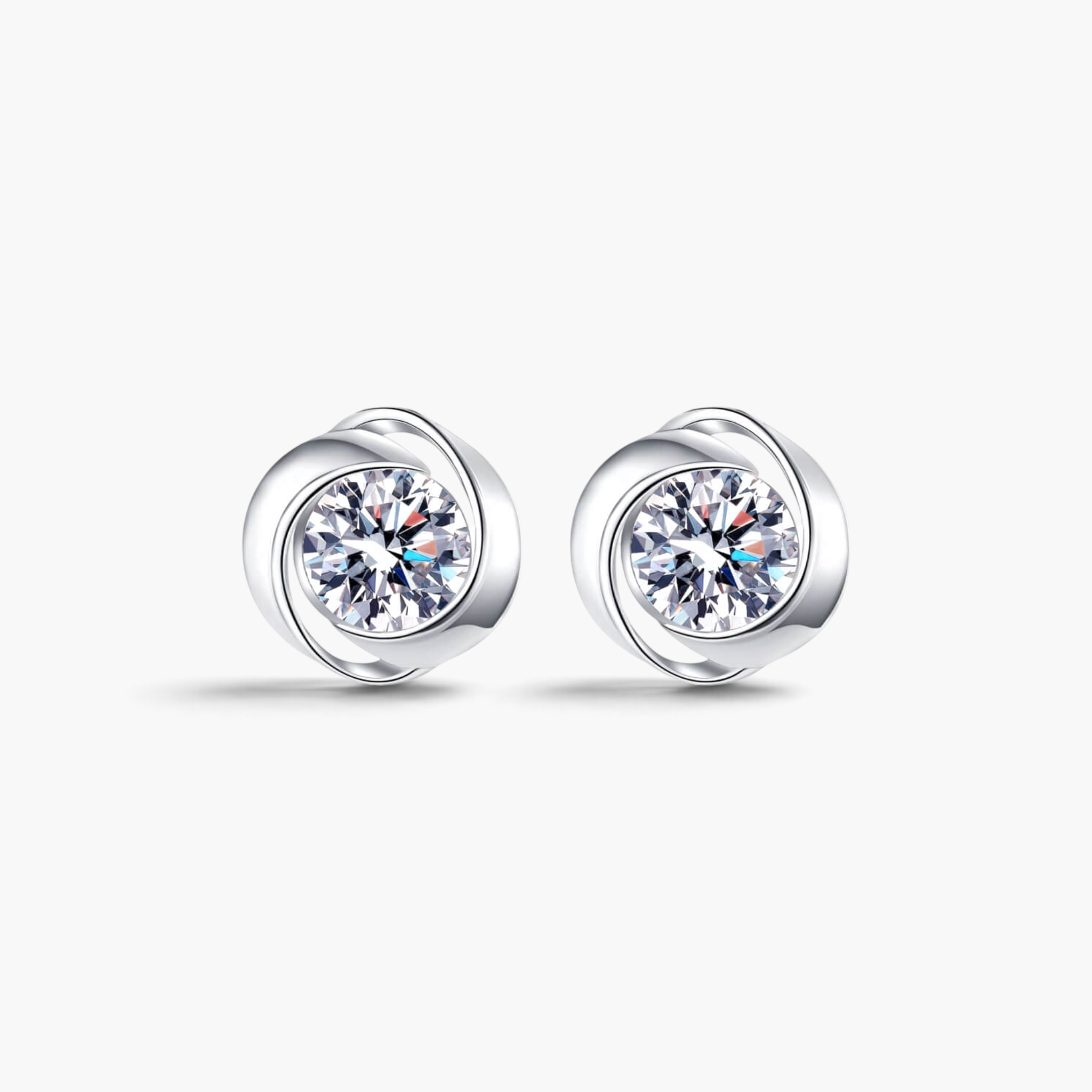 Beach Rose Co. round moissanite stud earrings in polished sterling silver with a modern swirling setting.