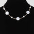 Beach Rose Co. gold cream necklace featuring polished stone beads and delicate charms on a black display bust
