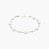 Beach Rose Co. gold cream necklace featuring polished stone beads and delicate charms on a thin metallic chain