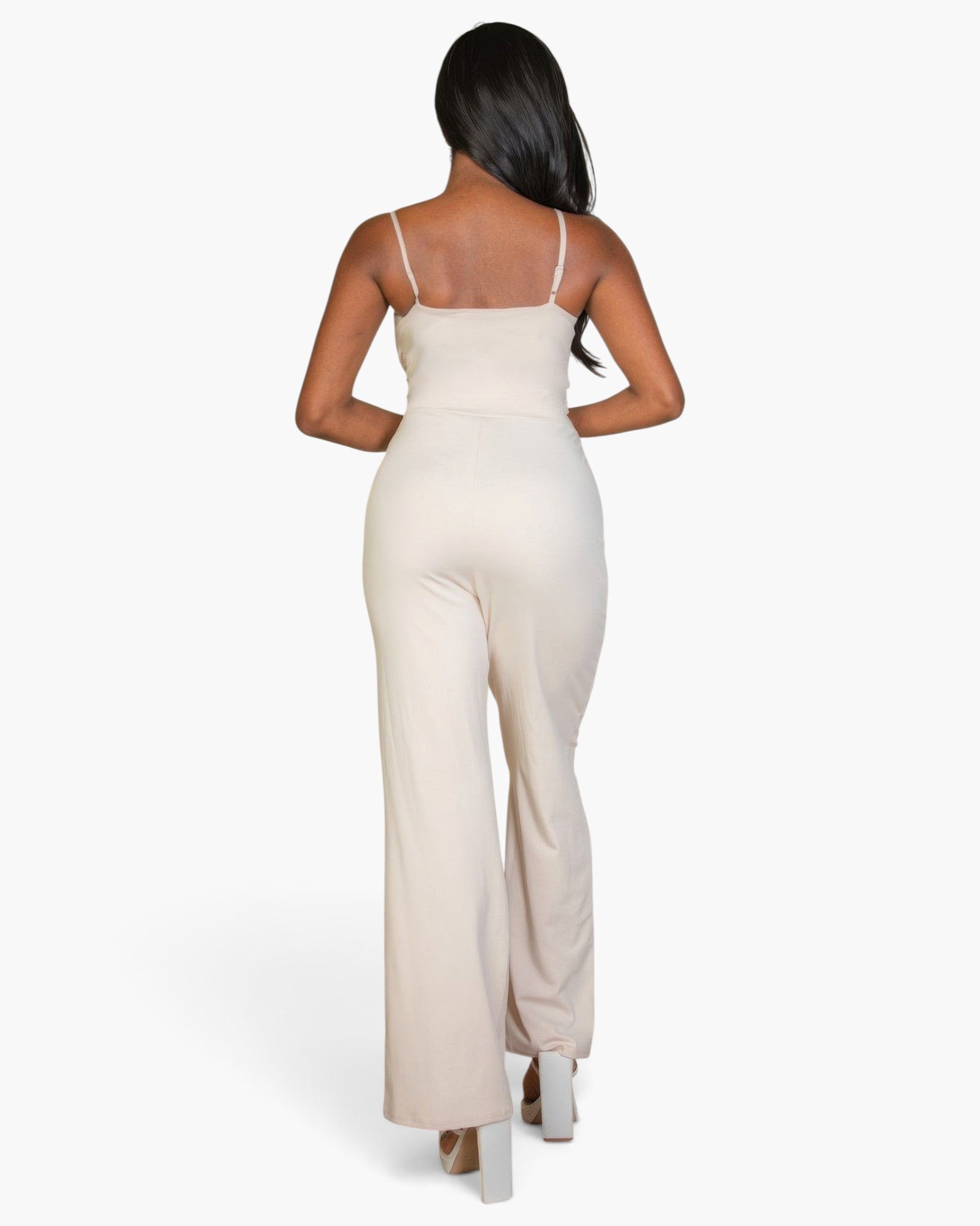 Beach Rose Co. stone-colored V-neck camisole jumpsuit on a model, back view showing sleek stretch knit fabric.