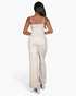 Beach Rose Co. stone-colored V-neck camisole jumpsuit on a model, back view showing sleek stretch knit fabric.