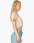 Beach Rose Co. stone-colored French Terry crop top with a toggle drawstring hem worn by a blonde model in profile.