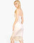 Beach Rose Co. stone ribbed halter neck midi dress with fringe hem worn by a blonde model in a side profile view