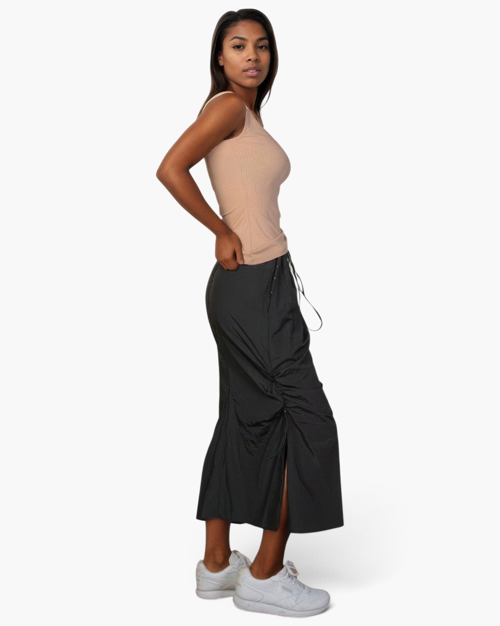 Beach Rose Co. stone ribbed V-neck sleeveless top worn by a model with a black midi skirt and white sneakers
