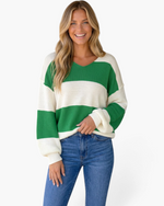 Beach Rose Co. green and cream striped V-neck sweater with balloon sleeves worn by a smiling woman with blonde hair.
