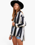 Beach Rose Co. model wearing a black and white striped polyester button-up shirt with dropped shoulders and a hat.