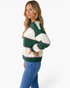 Beach Rose Co. model wearing a forest green and cream striped crewneck sweater with pink accents and drop shoulders.
