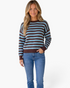 Beach Rose Co. model wearing a relaxed blue and chocolate brown striped crewneck sweater with ribbed trim and denim.
