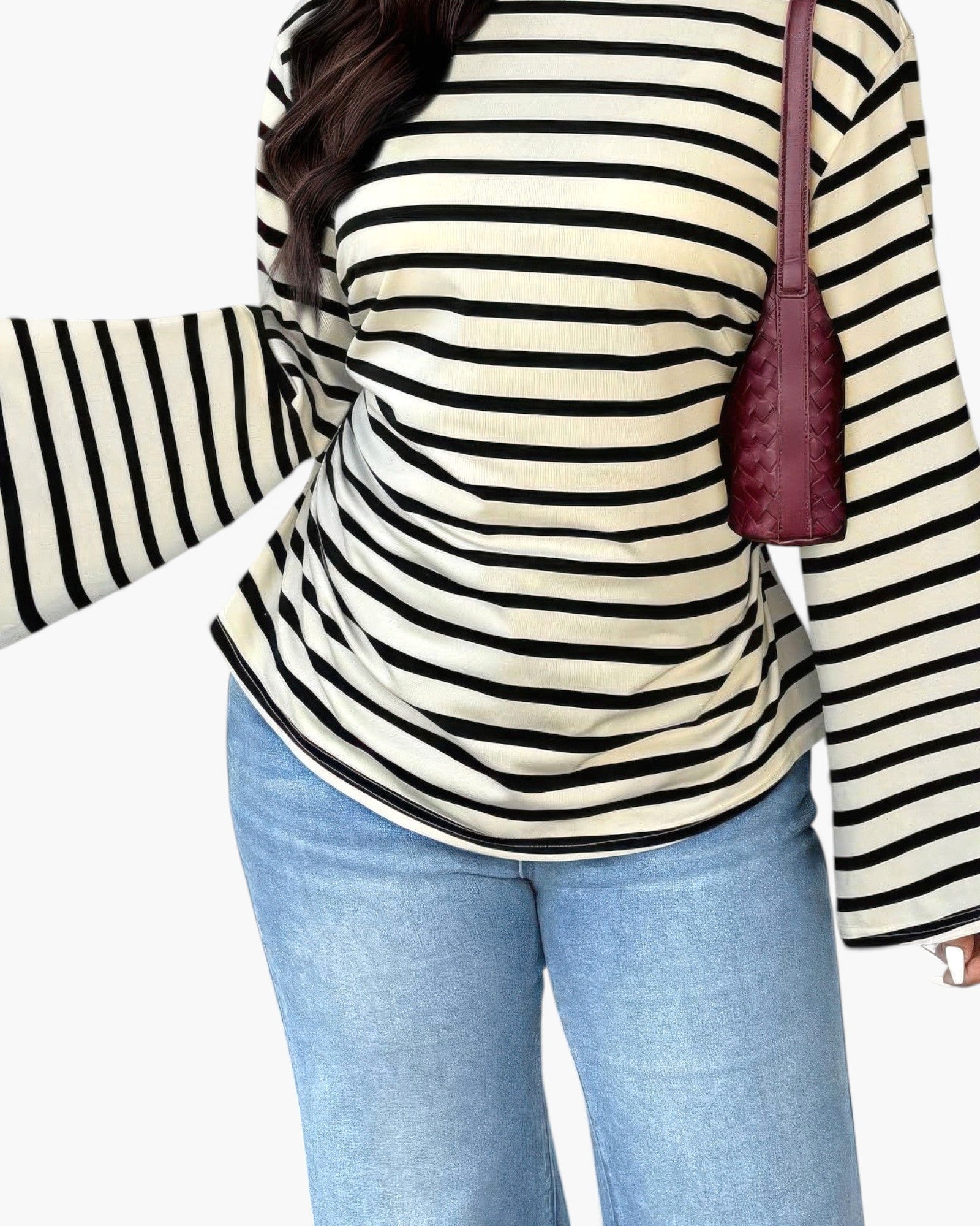 A person wearing a cream and black horizontally striped long-sleeve top with blue jeans, carrying a small burgundy shoulder bag against a plain white background.