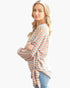 Beach Rose Co. model wearing a soft orange and blue striped long sleeve top with a side tie ribbon detail.
