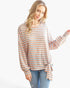 Beach Rose Co. model wearing a relaxed-fit orange tri-tone striped long sleeve top with a side tie ribbon detail