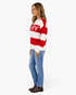 Beach Rose Co. red and cream striped crewneck sweater with MERRY lettering worn by a woman with jeans and boots