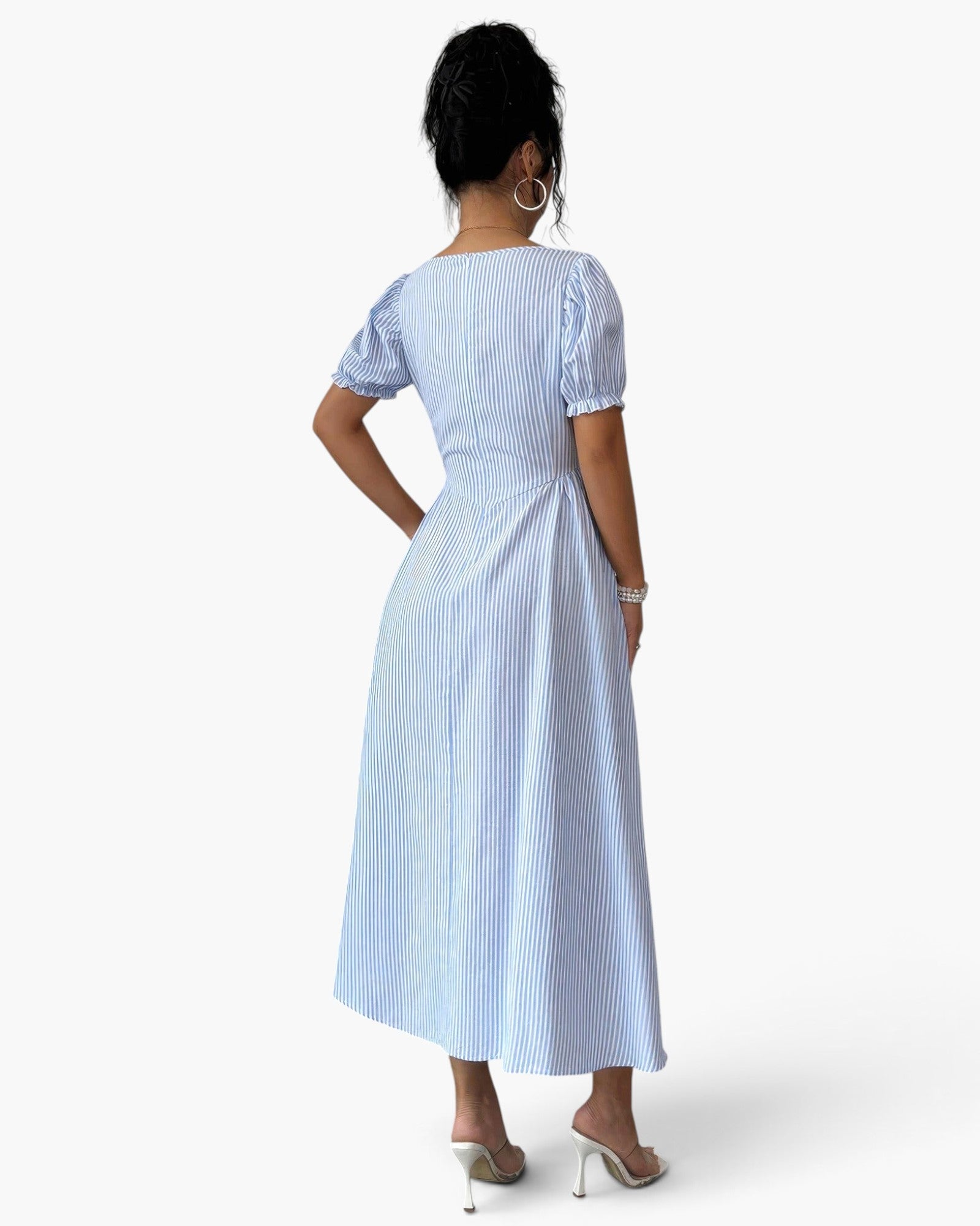 Beach Rose Co. blue and white striped midi dress with puff sleeves and backless design on a model