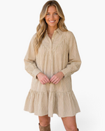 Beach Rose Co. taupe and ivory vertical striped mini shirt dress with a ruffle hem and long sleeves on a smiling model