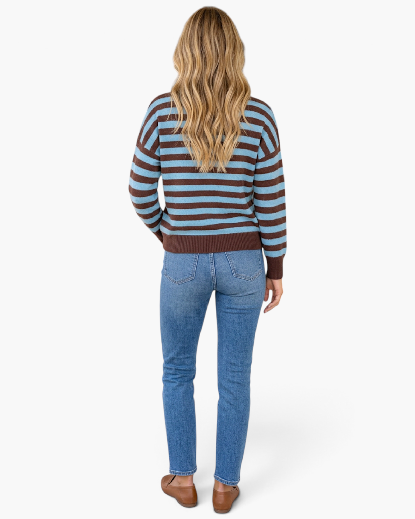 Beach Rose Co. model wearing a blue and chocolate brown striped crewneck sweater with jeans from a back view