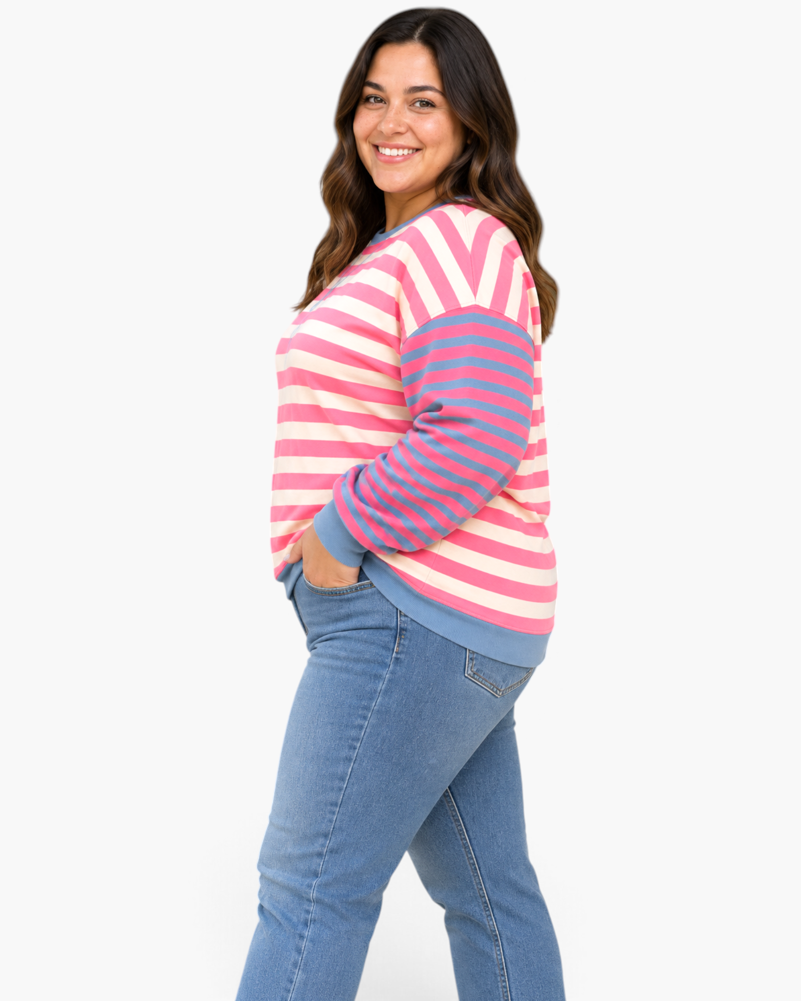 Beach Rose Co. model wearing a pink and cream striped sweatshirt with blue sleeves and trim, paired with blue jeans.