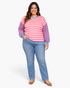 Beach Rose Co. model wearing a pink and cream striped sweatshirt with blue sleeves and trim, paired with blue jeans.
