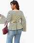A woman shown from the back wearing a cream and black horizontally striped long-sleeve top with a drawstring waist, paired with light blue jeans and carrying a dark red textured handbag, against a plain white background.