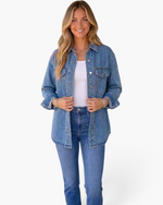 Beach Rose Co. blue denim shirt with metallic stud details, worn open over a white tank top and jeans