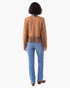 Beach Rose Co. tan faux suede jacket with long fringe detailing on the back and sleeves, worn with blue jeans.