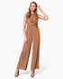 Beach Rose Co. model wearing a tan washed poly silk jumpsuit with a twist-front detail and wide-leg silhouette.