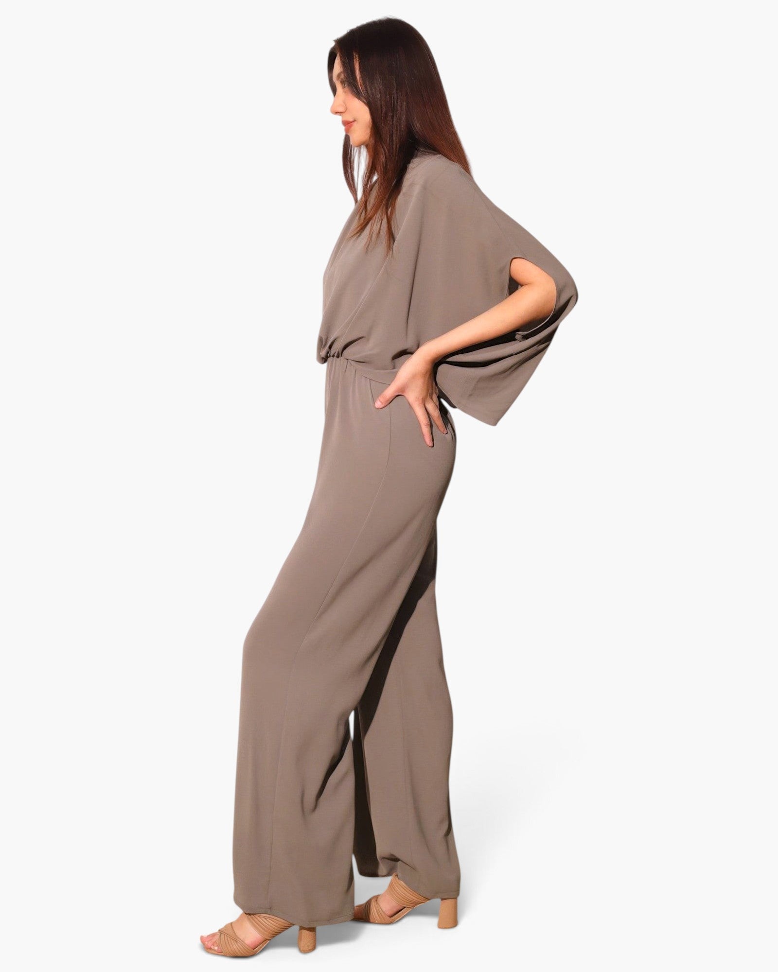 Model wearing a Beach Rose Co. taupe textured mock neck caftan jumpsuit with wide sleeves and a flowing silhouette.