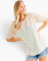 Beach Rose Co. relaxed fit taupe and light gray colorblock short sleeve tee worn by a smiling woman with denim shorts