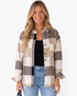 Beach Rose Co. taupe and cream plaid button-front shacket with chest pockets worn by a smiling woman