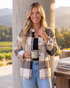 Beach Rose Co. taupe and cream plaid button-front shacket with chest pockets worn by a woman holding a coffee mug.