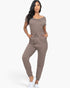 Beach Rose Co. taupe two-way shoulder drawstring jumpsuit with tapered legs and pockets worn by a model