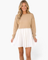 Beach Rose Co. taupe sweatshirt bodice mini dress with a gathered ivory skirt and long sleeves on a smiling model.
