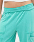 Beach Rose Co. teal mineral wash cotton cargo pants with a high-rise elastic waistband and raw edge pocket details.