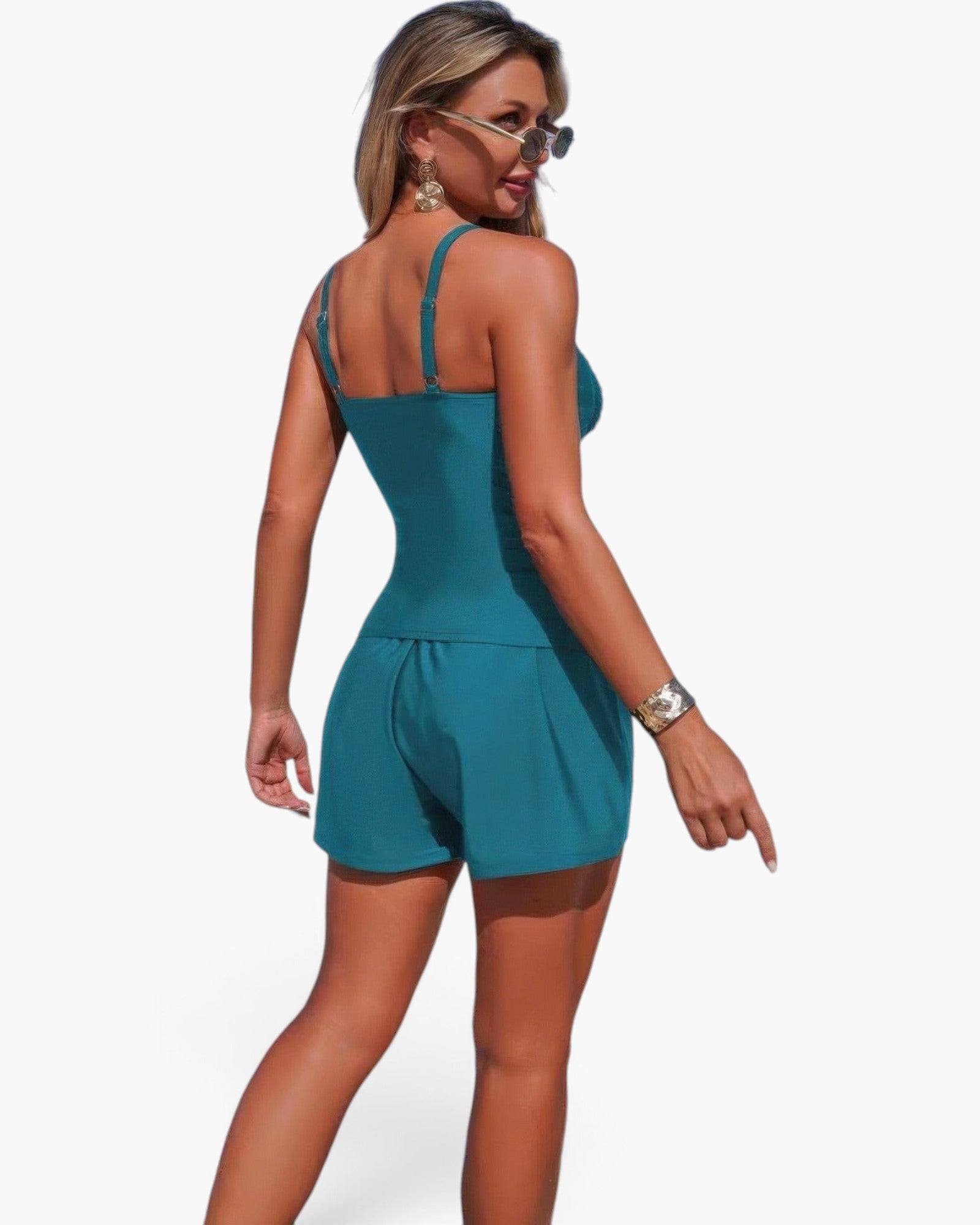 Beach Rose Co. teal two-piece swimsuit with sling straps, pleated shorts, and pocket accents on a model