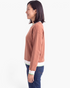 Beach Rose Co. terracotta crewneck sweatshirt with striped trim on cuffs and hem, worn by a woman in profile view.