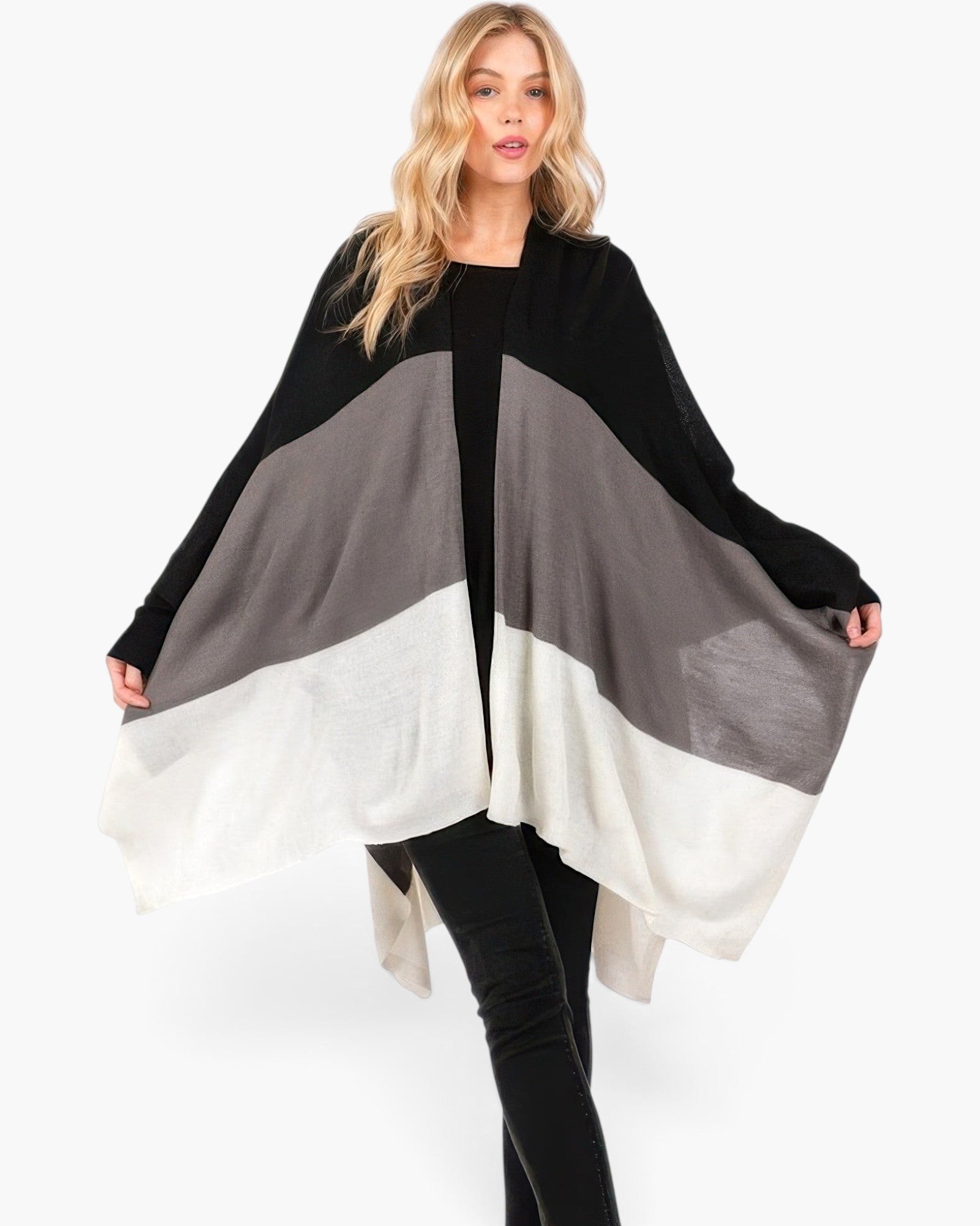 Beach Rose Co. Three Tones Ruana in black, grey, and white acrylic knit worn by a blonde model on white background.