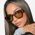 Beach Rose Co. oversized angular sunglasses with a tortoiseshell frame and gradient lenses worn by a woman.