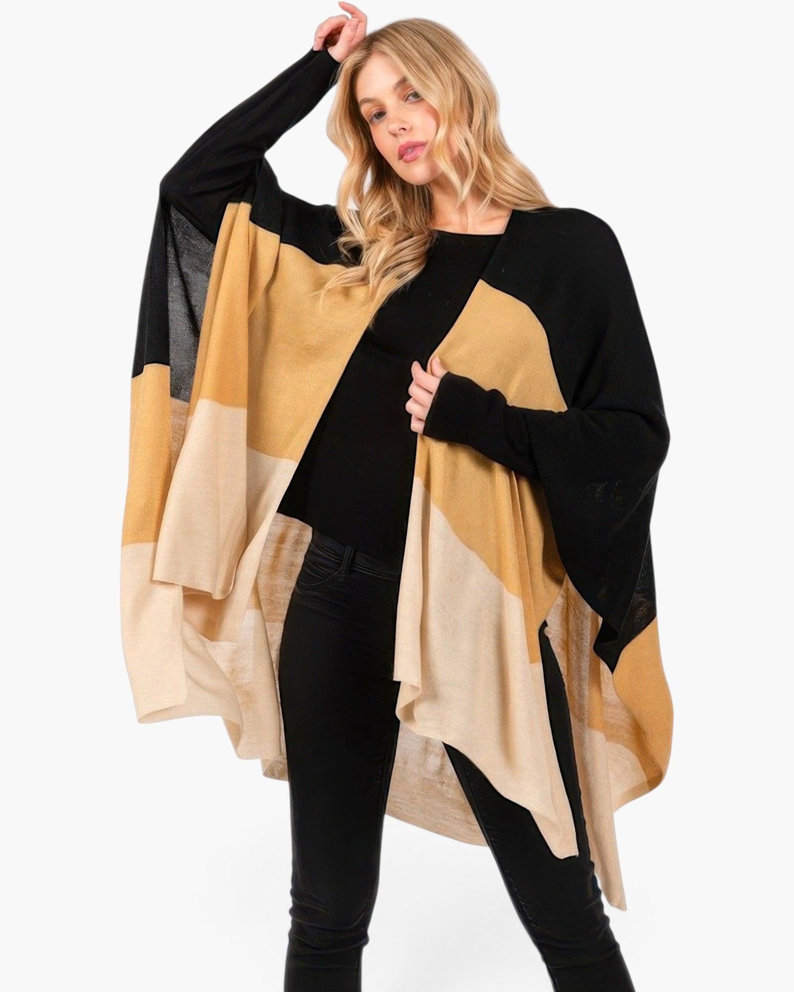 Beach Rose Co. model wearing a soft, lightweight acrylic ruana with a tri-tone black, tan, and beige knit design.
