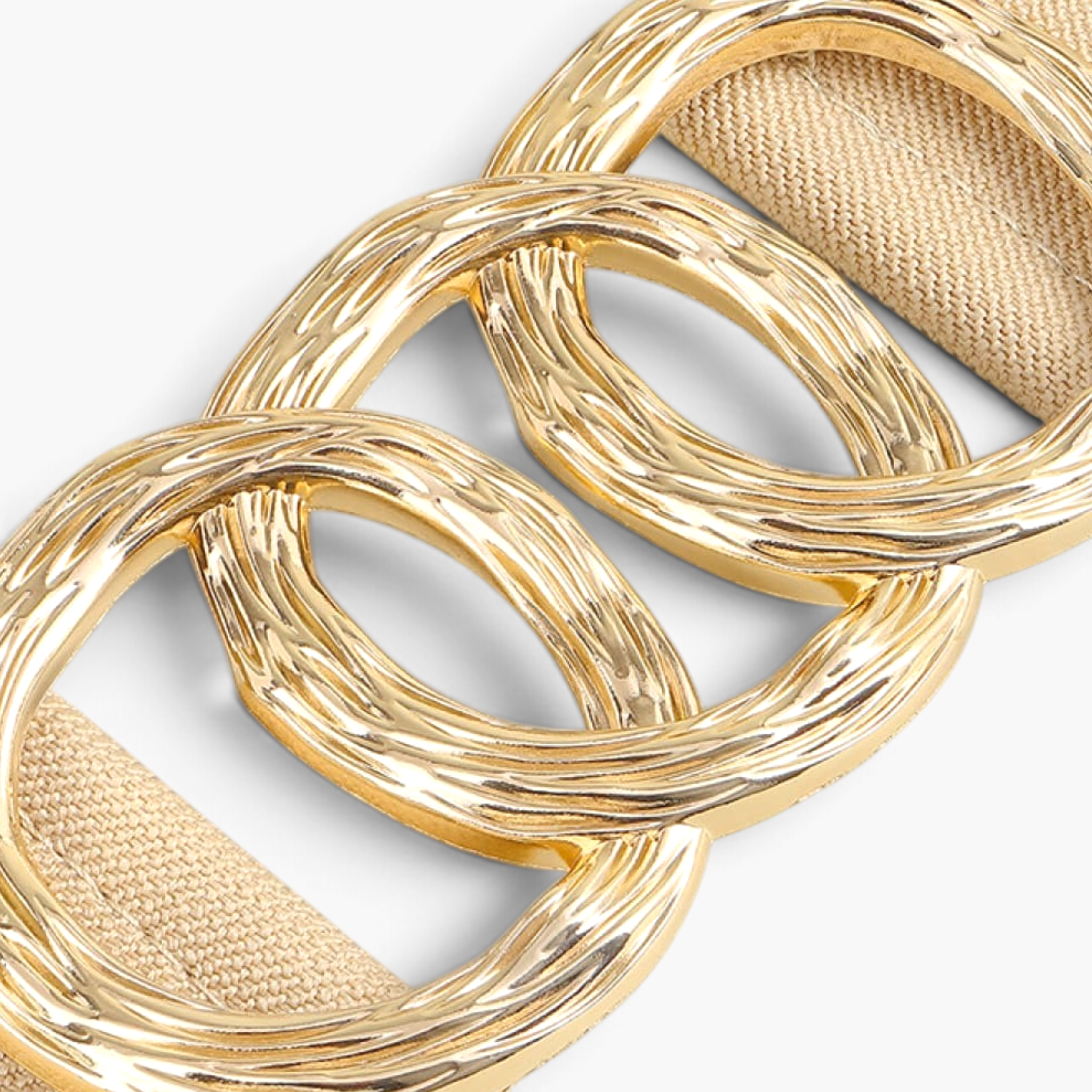Beach Rose Co. wide beige elastic belt featuring a triple overlapping textured gold metal ring buckle.
